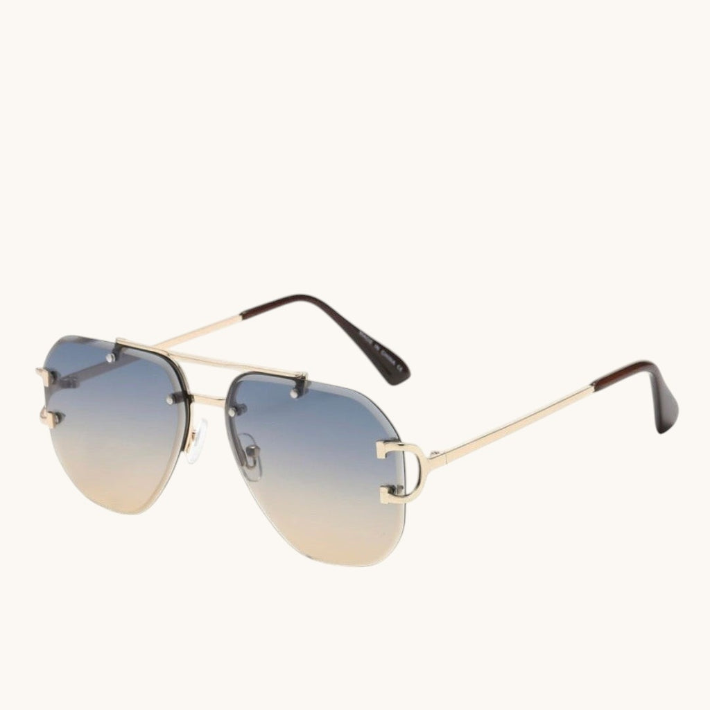Luxray CO Horseshoe Aviator rimless sunglasses with gold metal frame, gradient blue-to-tan lenses, and horseshoe detail on temples.